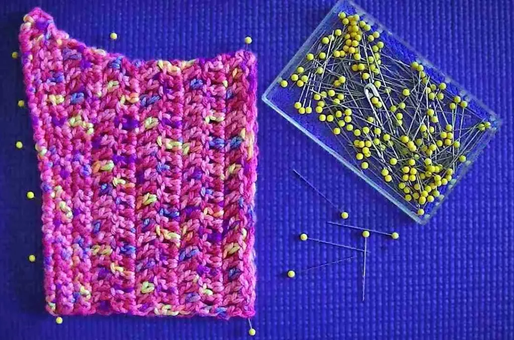 Virkad ruta som blockas på ett klarblått underlag med knappnålar.